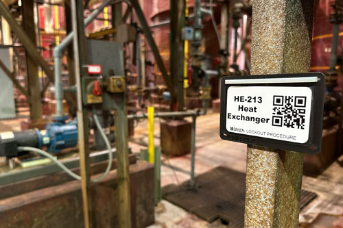 An energy source tag with a QR code mounted on a concrete column.