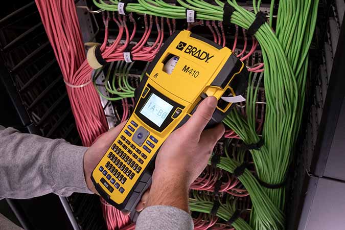 An worker using an M410 label printer to create labels for a complex server configuration. 