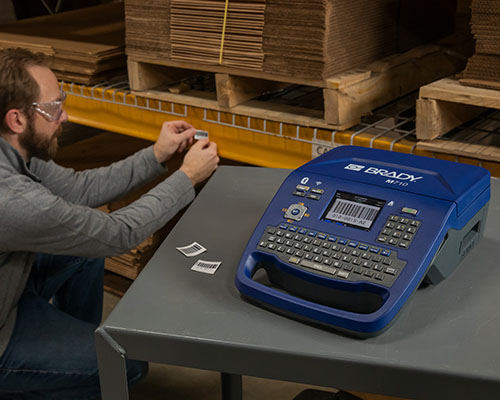 A label printed on the M710 printer is applied to industrial shelving.