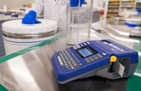 A lab technician prepares to label a group of samples with a Brady M510 portable label printer.