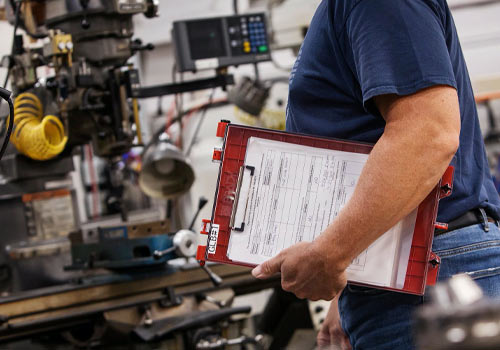 Man holding a clipboard with paperwork