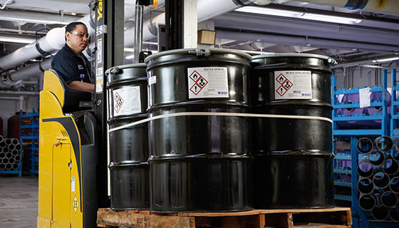 Man on forklift moving barrels