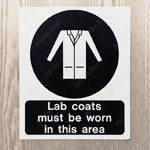 The lab coat PPE safety symbol is stamped outside an entryway.