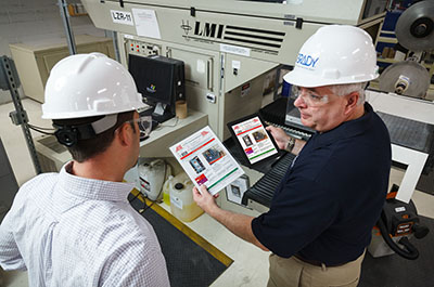 Two employees engaged in lockout tagout training, collaboratively updating their knowledge on the latest lockout procedures.