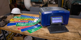 A Brady S3700 on a benchtop printing out pipe markers for proper pipe identification.