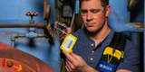 An employee applying a plastic valve tag to an air compression system.