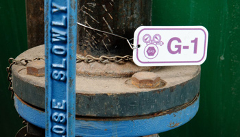 Close-up image of a white and purple valve tag labeled 'G-1' for gas valve identification.